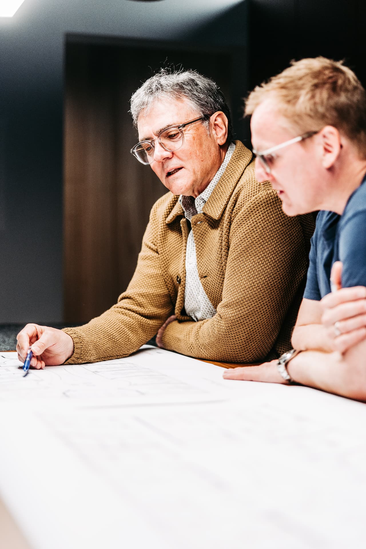 Jochen Köb von KOEB Finanz bespricht Unterlagen und Pläne mit einem Unternehmer